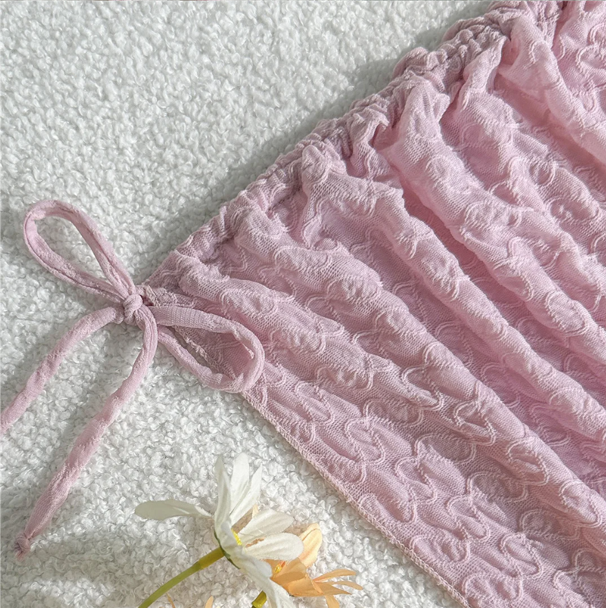 Close-up of Maya pink textured ruched mini skirt with adjustable side-tie detail.