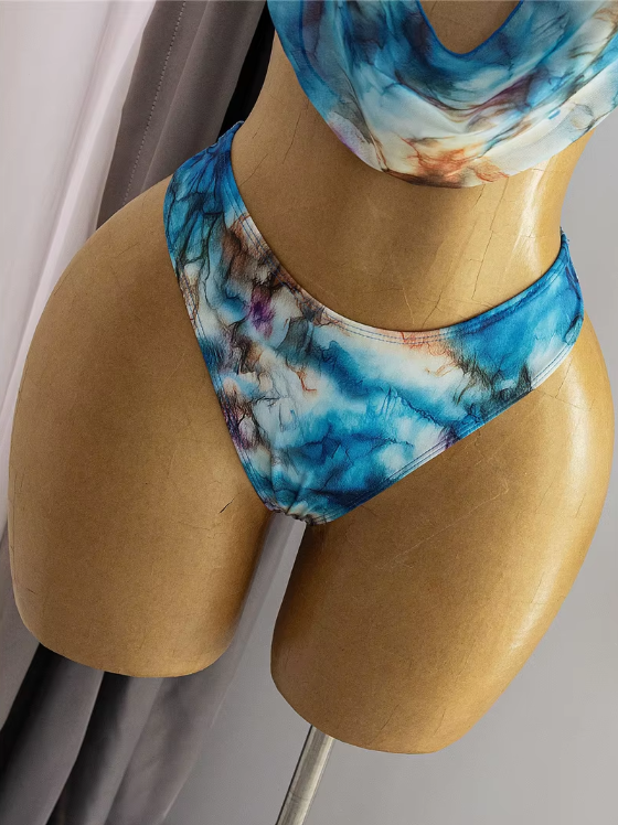 Close-up of blue watercolour bikini bottoms with abstract marble print and smooth high-leg shape.