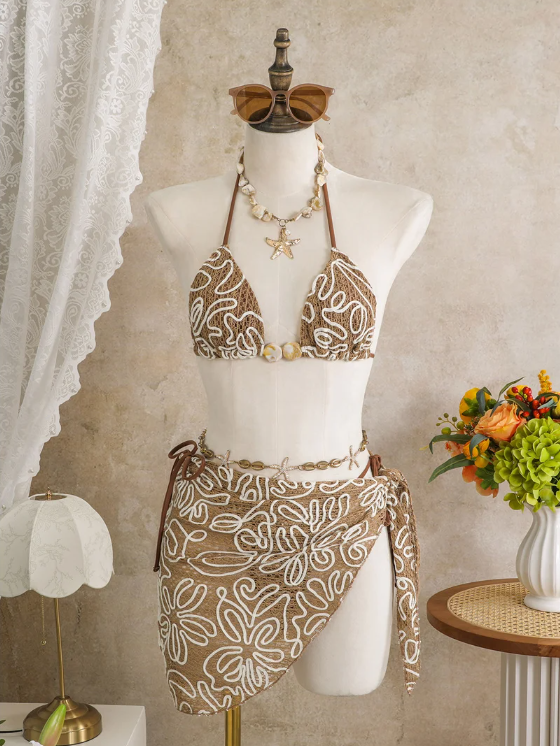 Cocoa Shell corded floral bikini and matching wrap sarong set displayed on mannequin with shell-inspired bead accents.