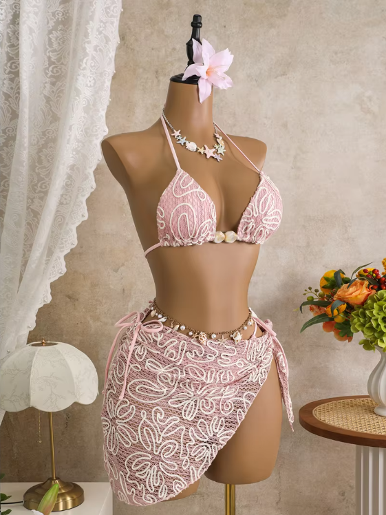 Angled front view of pink embroidered bikini and wrap sarong set with triangle halter top and shell-style centre accents.