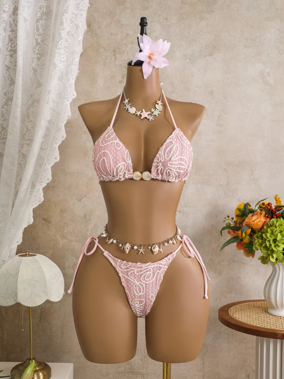 Pink corded floral triangle bikini set with shell-inspired centre beads and tie-side high-leg bottoms on mannequin.