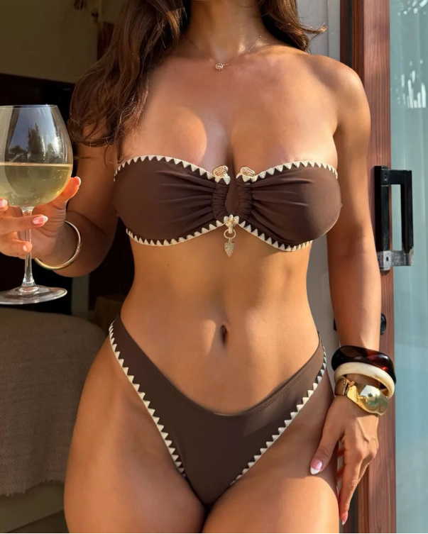 Chocolate brown bandeau bikini set with cream whipstitch trim and shell charm detail worn by model.