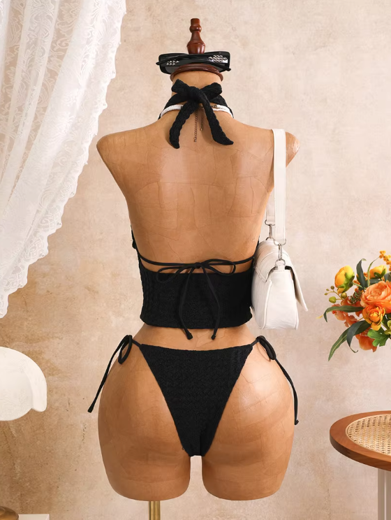 Back view of black textured bikini set with halter neck tie, back tie fastening and tie-side high-leg bottoms.