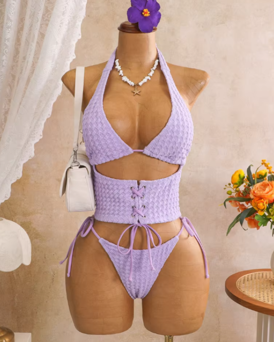 Lilac textured halter bikini set displayed on mannequin with lace-up waist panel and tie-side bottoms.