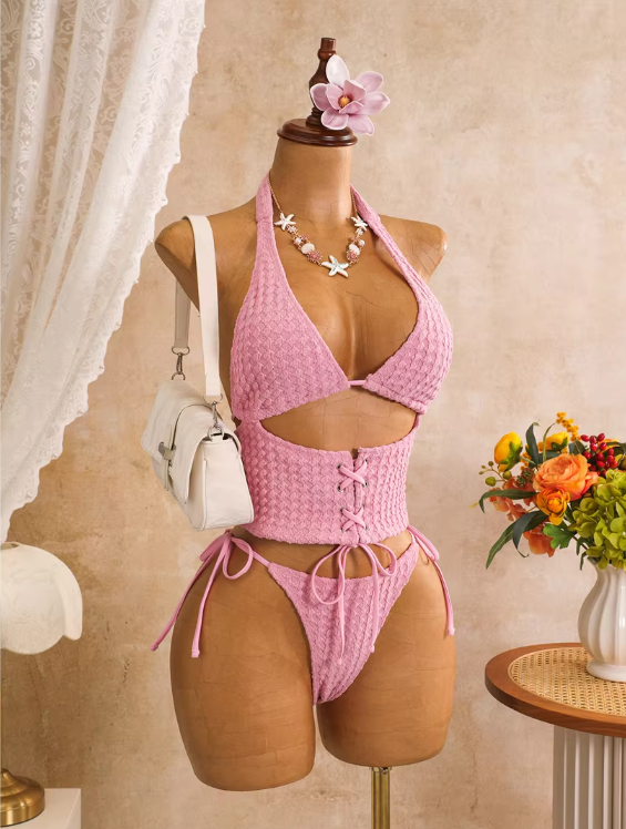 Angled front view of pink corset-inspired bikini set with halter bodice, front cut-out and lace-up waist detail.