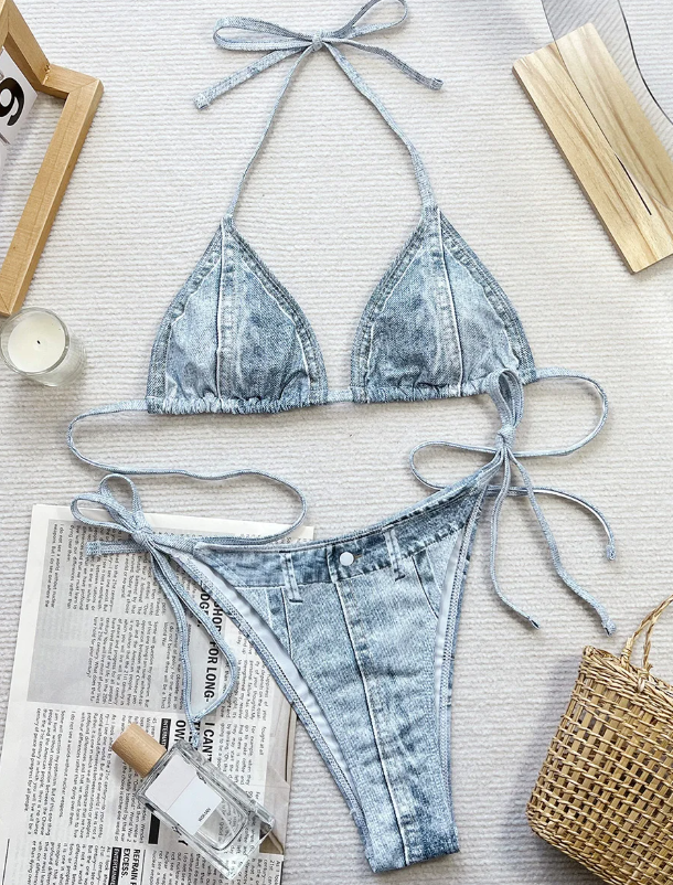 Flat lay front view of denim-look bikini set with triangle halter top and matching tie-side bottoms.