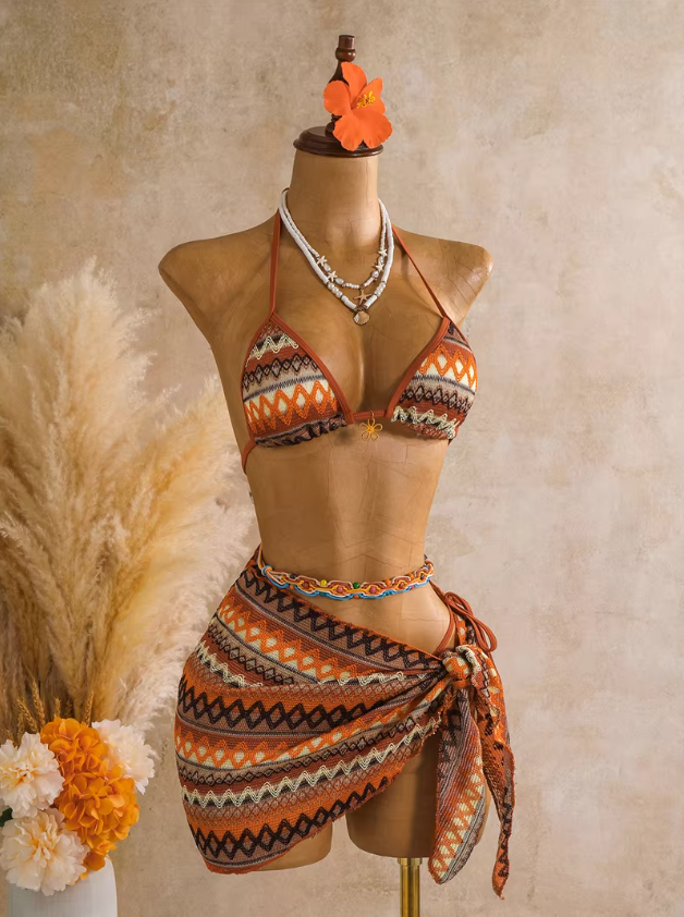 Saffron orange textured triangle bikini and matching wrap sarong set displayed on mannequin with warm resort styling.