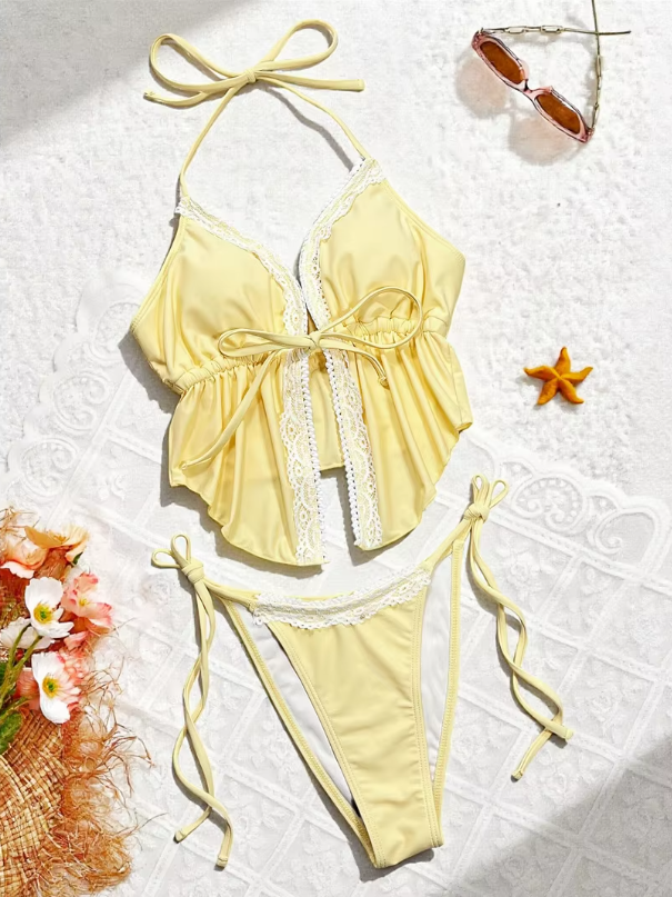 Soleil yellow tankini set flat lay with halter peplum top, lace trim and high-leg tie-side bikini bottoms.