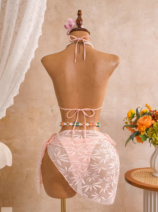 Back view of camellia blush openwork bikini and matching wrap sarong with halter neck tie and back tie fastening.