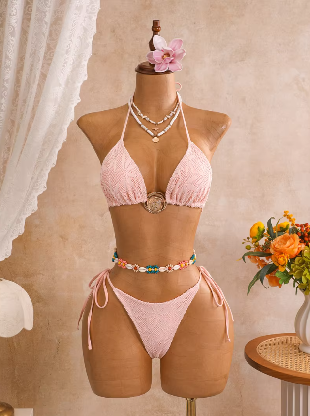 Camellia blush botanical openwork triangle bikini set with gold-tone centre hardware and tie-side bottoms displayed on mannequin.