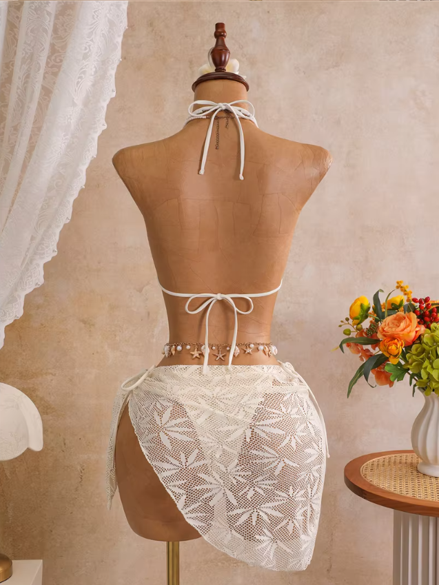 Back view of ivory openwork bikini and matching wrap sarong with halter neck tie and back tie fastening.