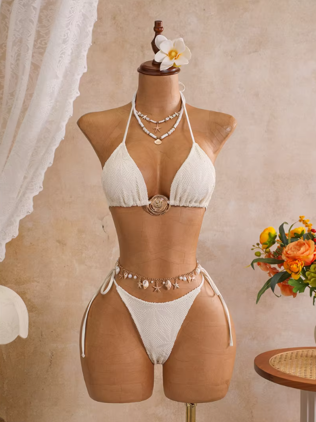 Ivory botanical openwork triangle bikini set with gold-tone centre hardware and tie-side bottoms displayed on mannequin.