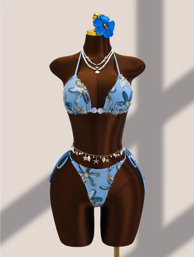 Aqua floral appliqué triangle bikini set with pearl-look centre beads and tie-side high-leg bottoms on mannequin.