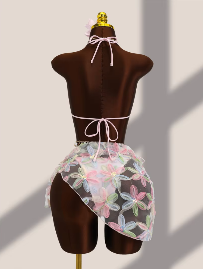 Back view of pink floral appliqué bikini and sheer wrap sarong set with halter tie, back tie and asymmetric sarong drape.