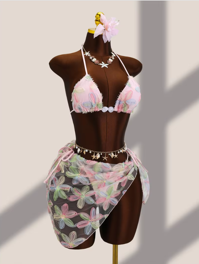 Front view of pink floral bikini and sheer sarong set with dimensional petal appliqué and delicate tie-side detailing.