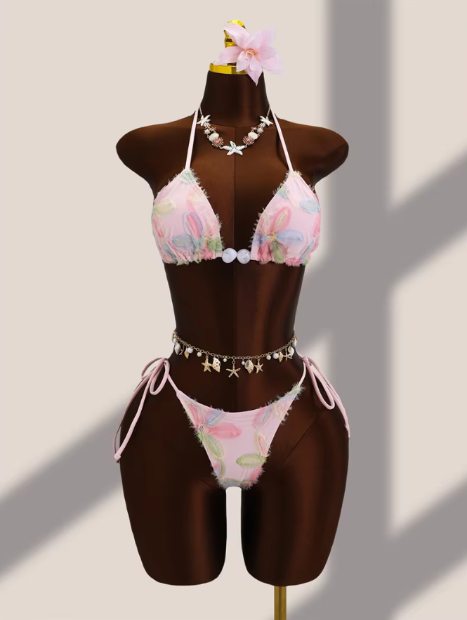 Pink floral appliqué triangle bikini set with pearl-look centre beads and tie-side high-leg bottoms on mannequin.