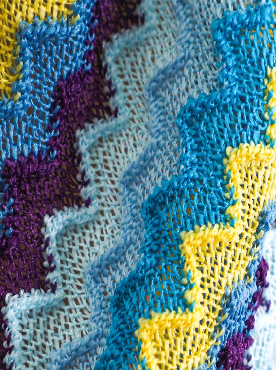 Close-up of aqua open-knit chevron fabric in blue, yellow and purple tones.
