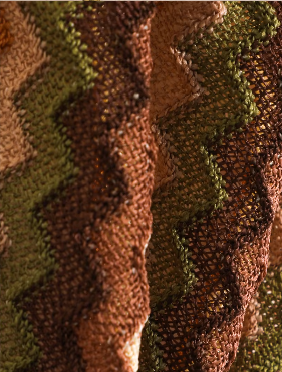 Close-up of cocoa open-knit chevron fabric in brown, olive, cream and orange tones.