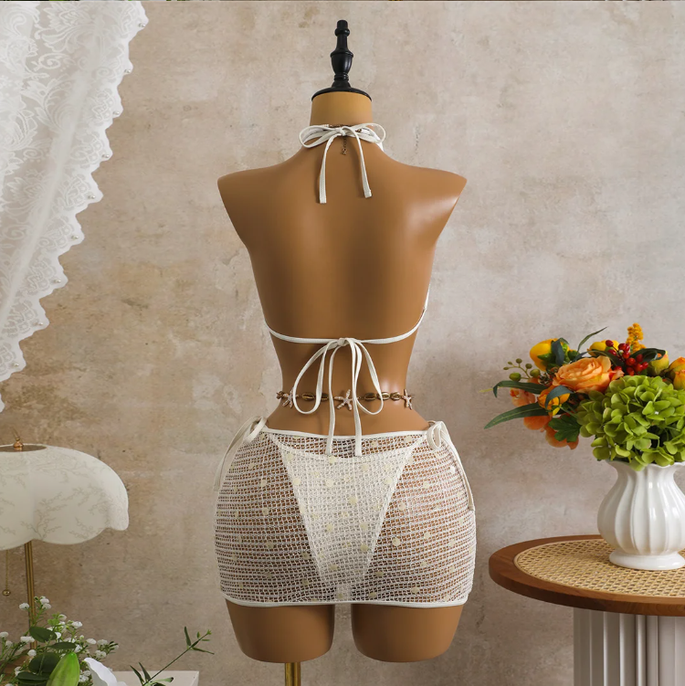 Back view of white crochet-look bikini and sheer mini skirt set with halter tie, back tie and open-knit skirt.