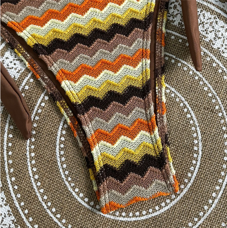 Close-up of earth-toned chevron stripe bikini bottoms with contrast brown binding and textured fabric.