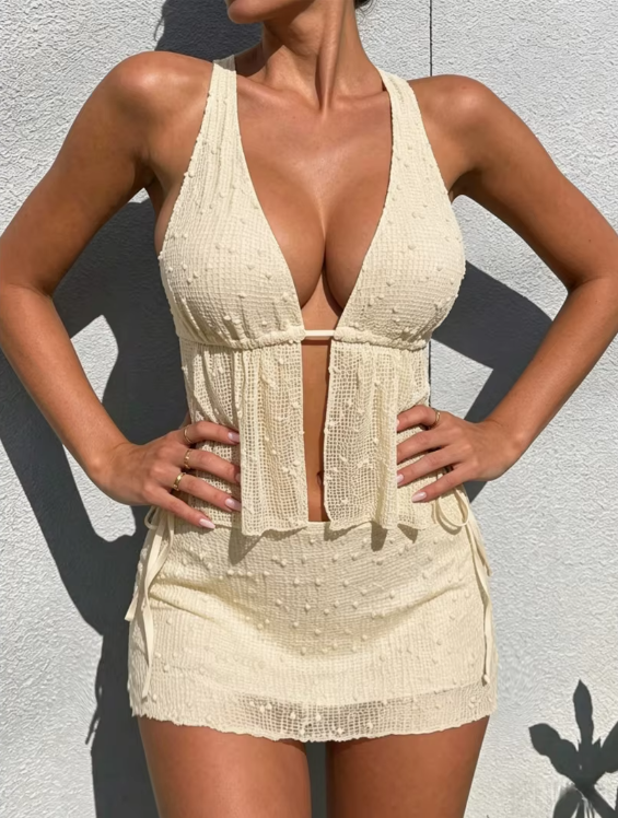 Cream textured tankini set with plunging halter neckline, peplum bodice detail and coordinating mini skirt.